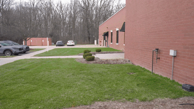 Person holding a smartphone that displays an augmented reality view of underground utilities on a site.